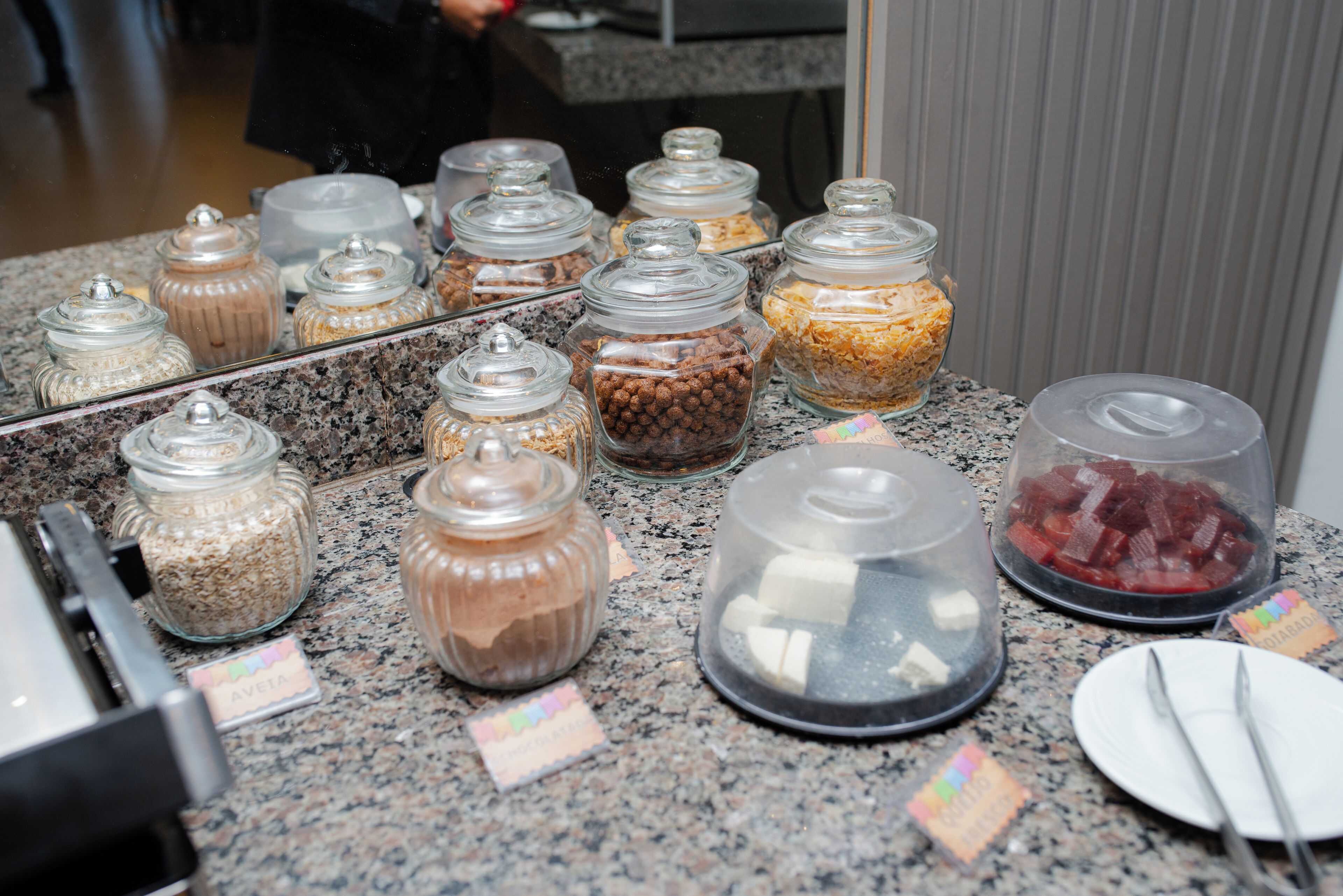 A buffet area with various food items in glass containers.