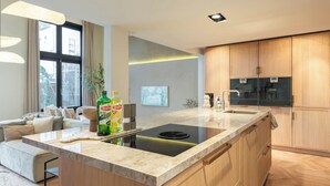 Una cocina moderna con una isla central, electrodomésticos integrados y un amplio ventanal.