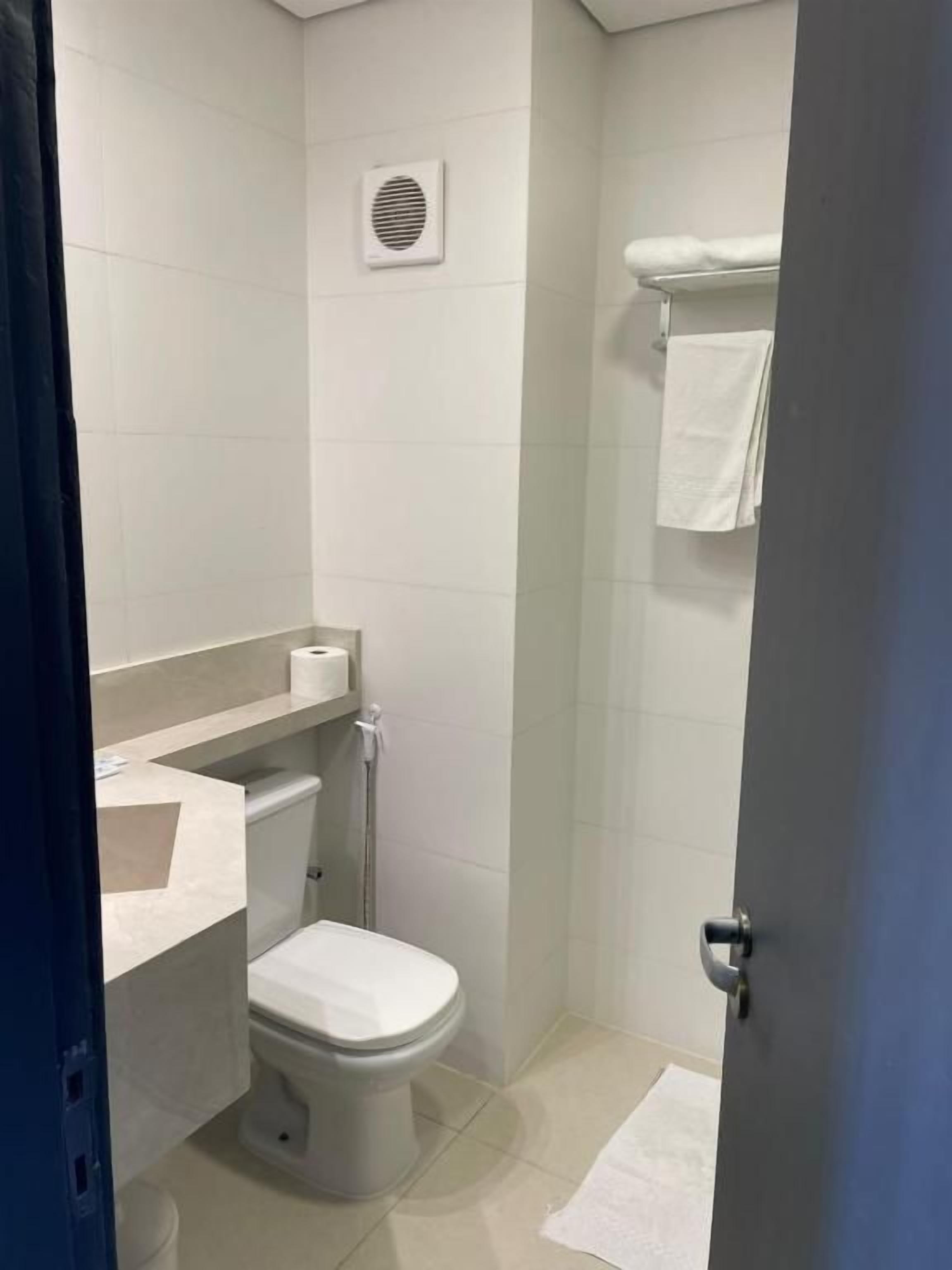 Baño pequeño y funcional con inodoro, lavamanos y zona de ducha.