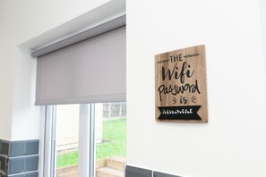 A bathroom with a window, a towel rack, and a sign on the wall. - Argyle House  (Tamworth)
