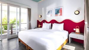 A hotel room with a large bed, a nightstand, a lamp, and a view of greenery through the window. - Villa Ungava (Seminyak)