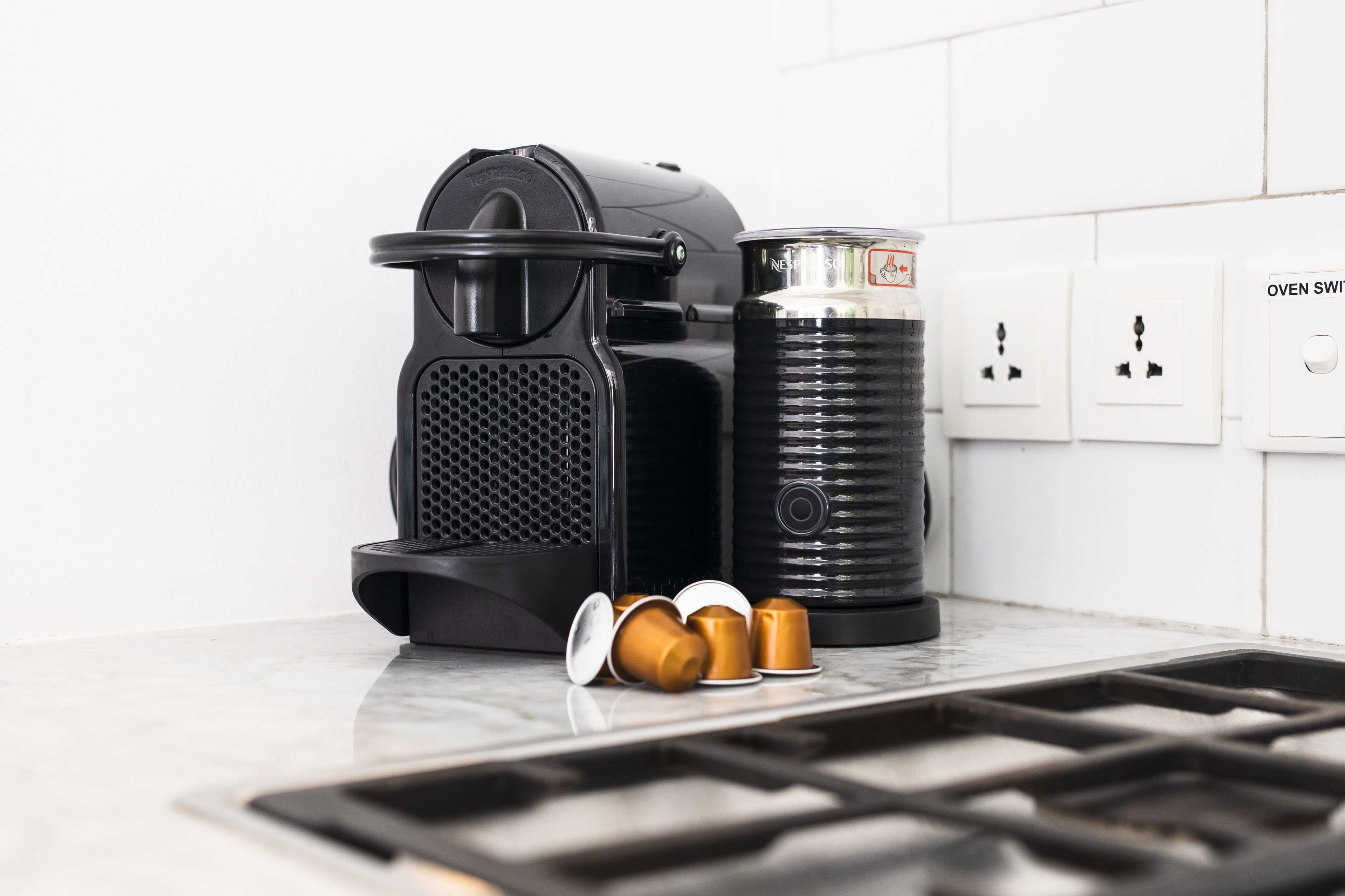 Een keuken met een koffiezetapparaat, een bak en een koffiepadapparaat.