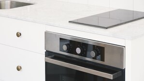 Una cocina con horno de acero inoxidable y placa de cocina integrada.