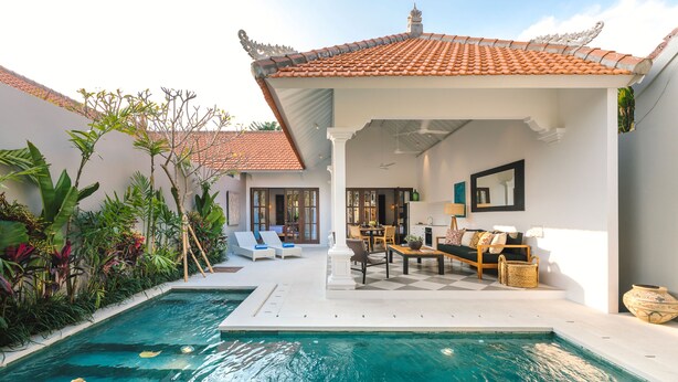 Zona junto a la piscina con un área de estar cubierta, una mesa de comedor y vistas a la piscina.