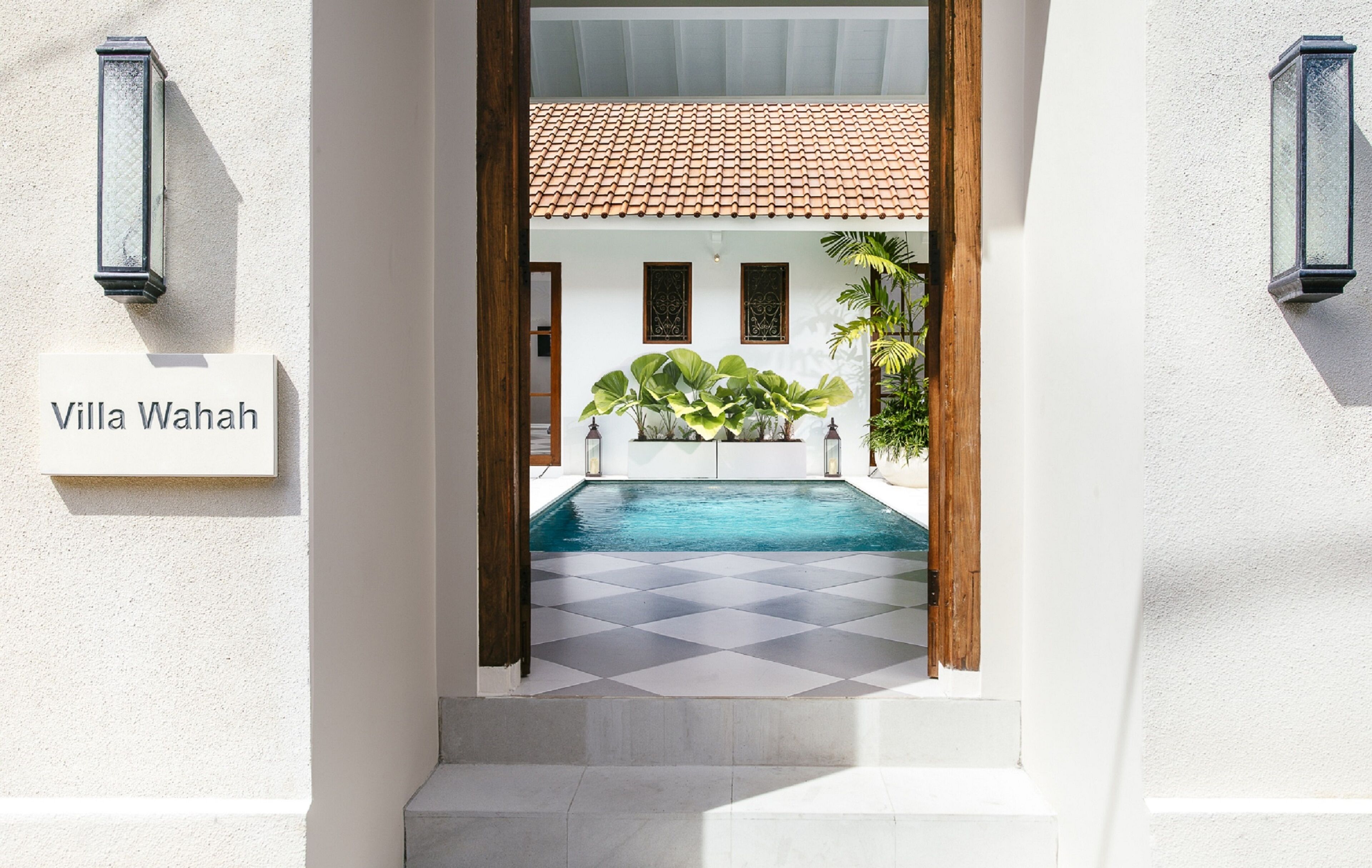 Una villa llamada Villa Wahah con piscina, suelo a cuadros y techo de tejas.