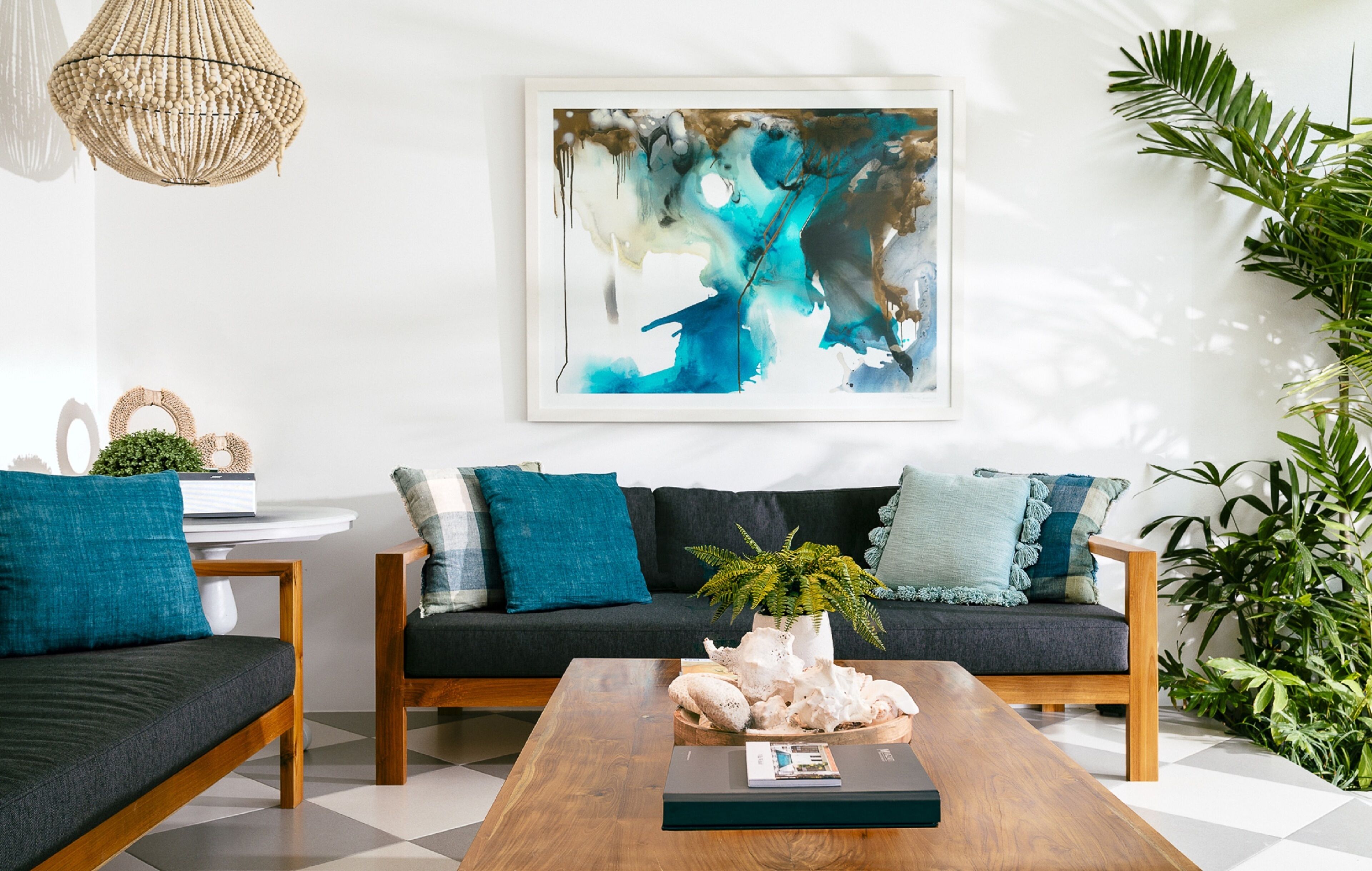 En moderne stue med en mørk sofa, et træbord og et stort abstrakt maleri på væggen.