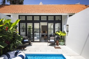 A modern house with a swimming pool, large windows, and outdoor seating. - Villa Chino (Seminyak)