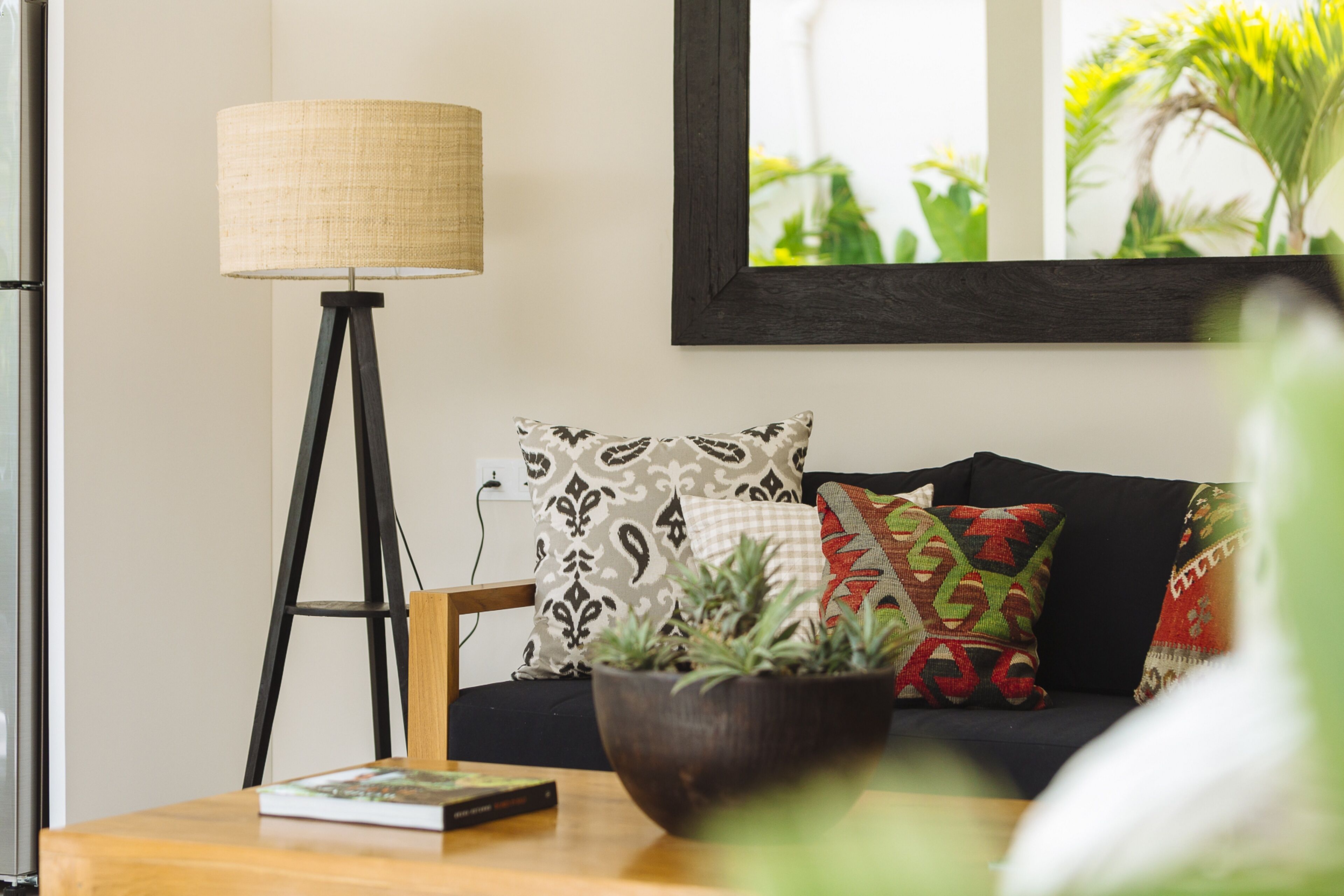 A living room with a dark-colored sofa, a wooden coffee table, a floor lamp, and a framed picture on the wall.