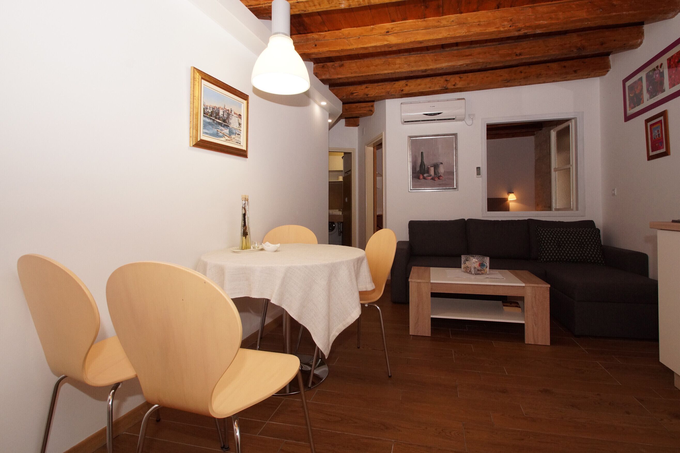 A dining area with a round table and chairs, a sofa, and a coffee table.