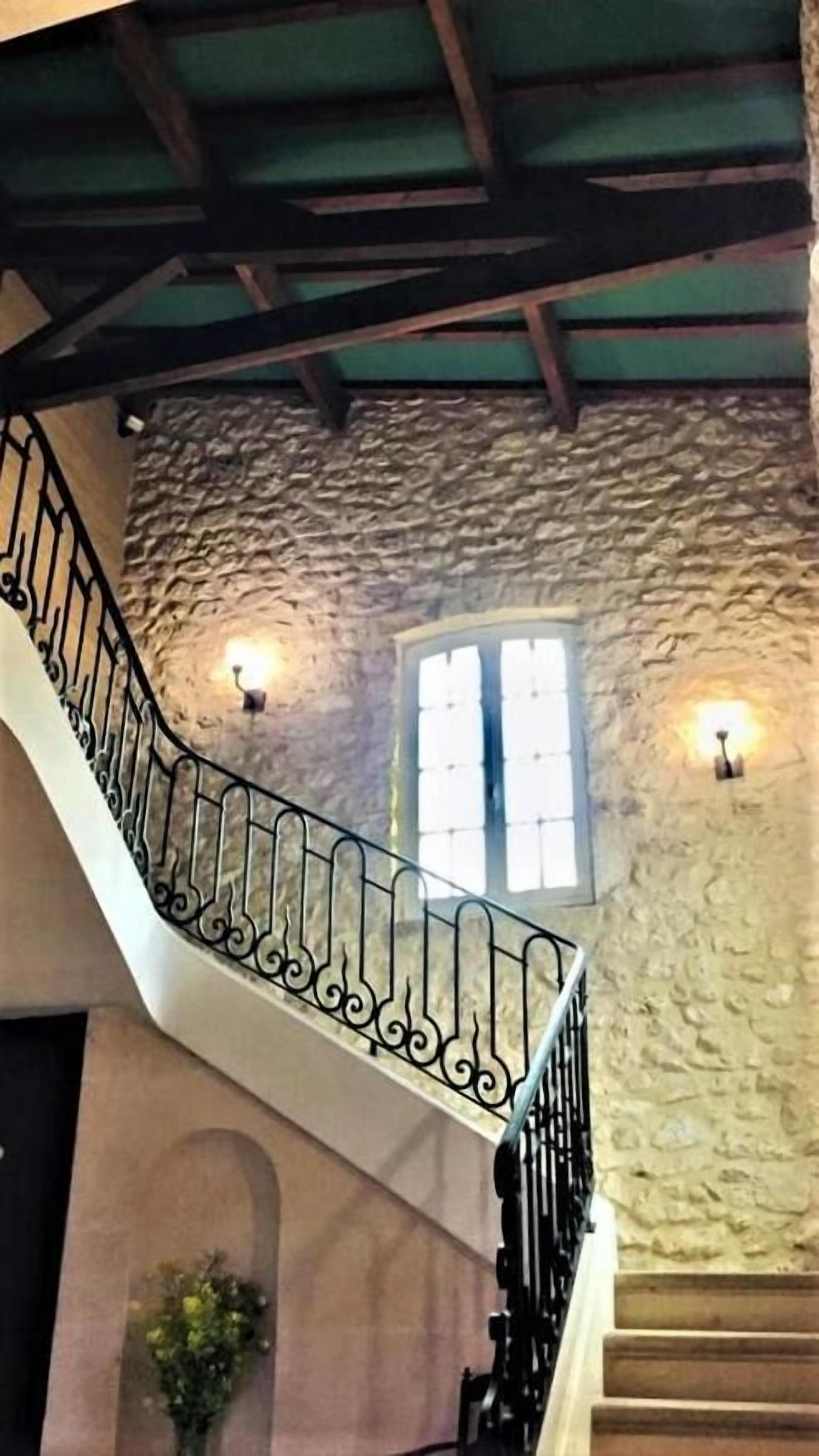 A staircase with a stone wall and a window.