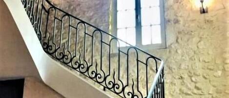 A staircase with a stone wall and a window.