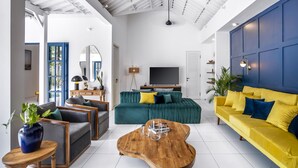 A modern living room with a sofa, coffee table, and a TV. - Beachhouse (Canggu)