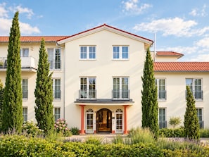 A two-story building with a symmetrical facade, multiple windows, and a central entrance with a door and columns. - Hotel Zielonka (Hochheim am Main)