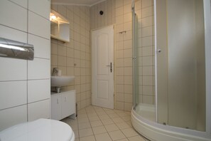 Un baño con inodoro, lavabo y ducha.