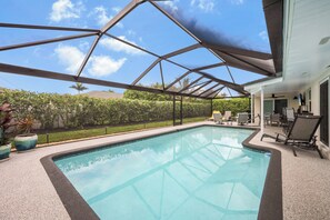 A covered swimming pool with a view of the sky and greenery.