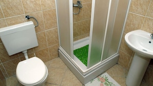 A bathroom with a toilet, a shower enclosure, and a sink. - Vita Apartments (Korcula)