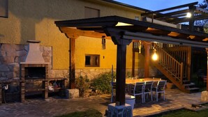 An outdoor patio with a stone fireplace, a covered seating area, and a staircase leading to an upper level. - Margasol - Housing for Tourist Use (PEDREZUELA)