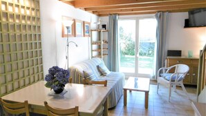 Una sala de estar acogedora con sofá, mesa de comedor, sillas y televisor.