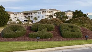 A landscaped area with neatly trimmed bushes and a mailbox.