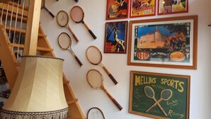 A staircase with a lamp, tennis rackets, and framed movie posters on the wall.