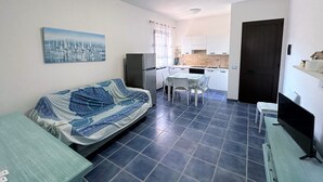 Ein gemütlicher Wohnbereich mit Sofa, Esstisch und Küchenzeile.