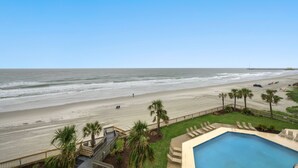 Ein Poolbereich mit Blick auf Strand und Meer.