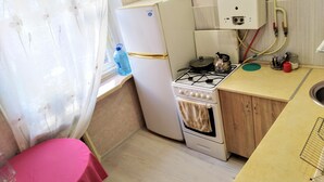 A compact kitchen with a refrigerator, stove, oven, and a sink. - Fontanskaya doroga 16/5 (Одесса)