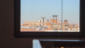 A window with a view of a cityscape, including buildings and a clear sky. - Mayor`s Study Loft at The Kestrel (Philadelphia)