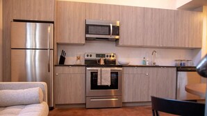 A compact kitchen with a refrigerator, microwave, oven, and sink. - Mayor`s Study Loft at The Kestrel (Philadelphia)