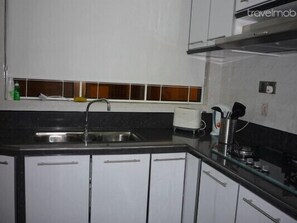 A compact kitchen with a sink, a toaster, and a kettle. - Cozy Condo with Stunning Sea View (Batu Ferringhi)