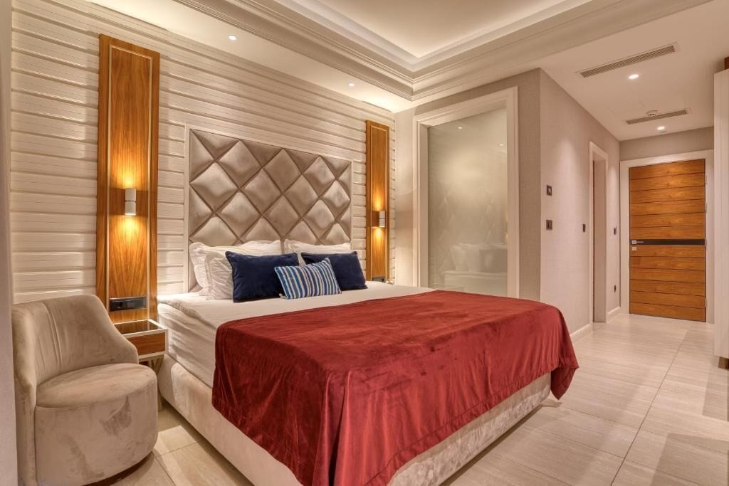 Un dormitorio moderno con una cama grande, una silla y un armario.
