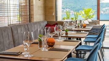 Un restaurante con mesas preparadas para comer, con vistas a las montañas.