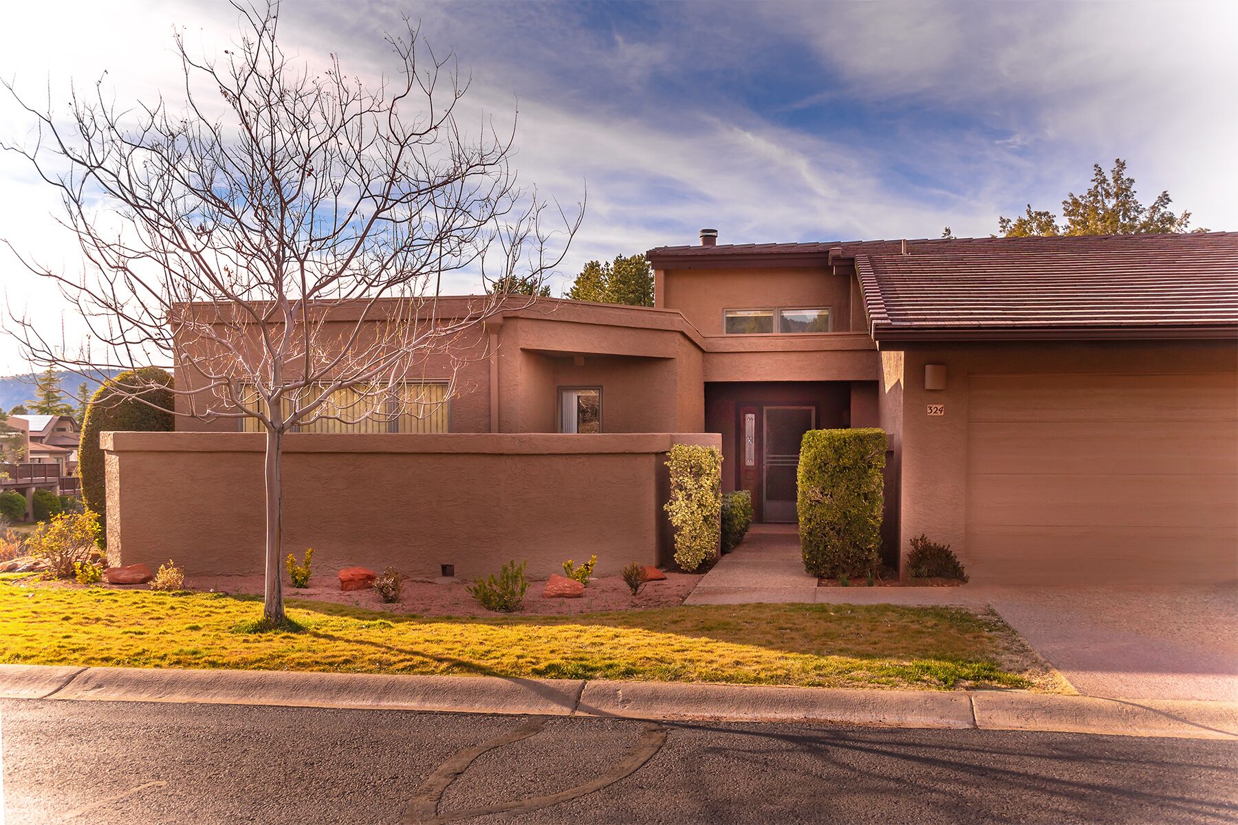 A two-story house with a brown exterior, a front door, and a garage.