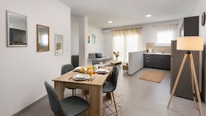 Un appartement moderne comprenant un coin repas, une kitchenette et un espace de vie.