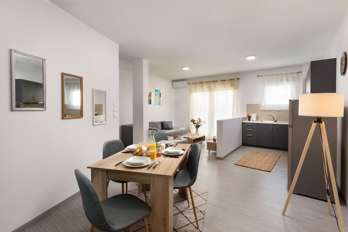 Een modern appartement met een eethoek, kitchenette en woonruimte.