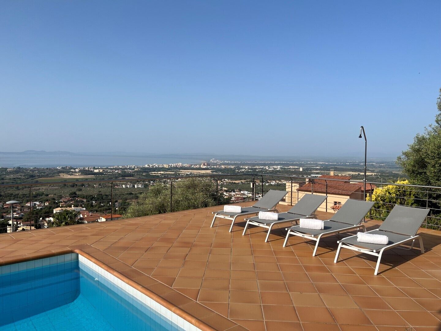 A rooftop pool with a clear view of a cityscape and mountains in the distance.