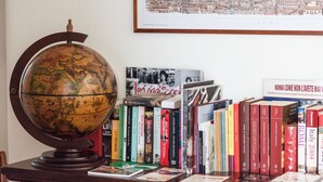 A globe, books, and a framed cityscape on a desk. - Bright room near the Vatican (Roma)