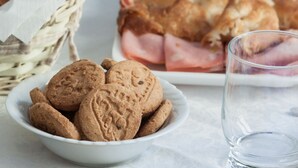 A bowl of cookies, a glass of water, and a plate of ham and bread on a table. - Bright room near the Vatican (Roma)