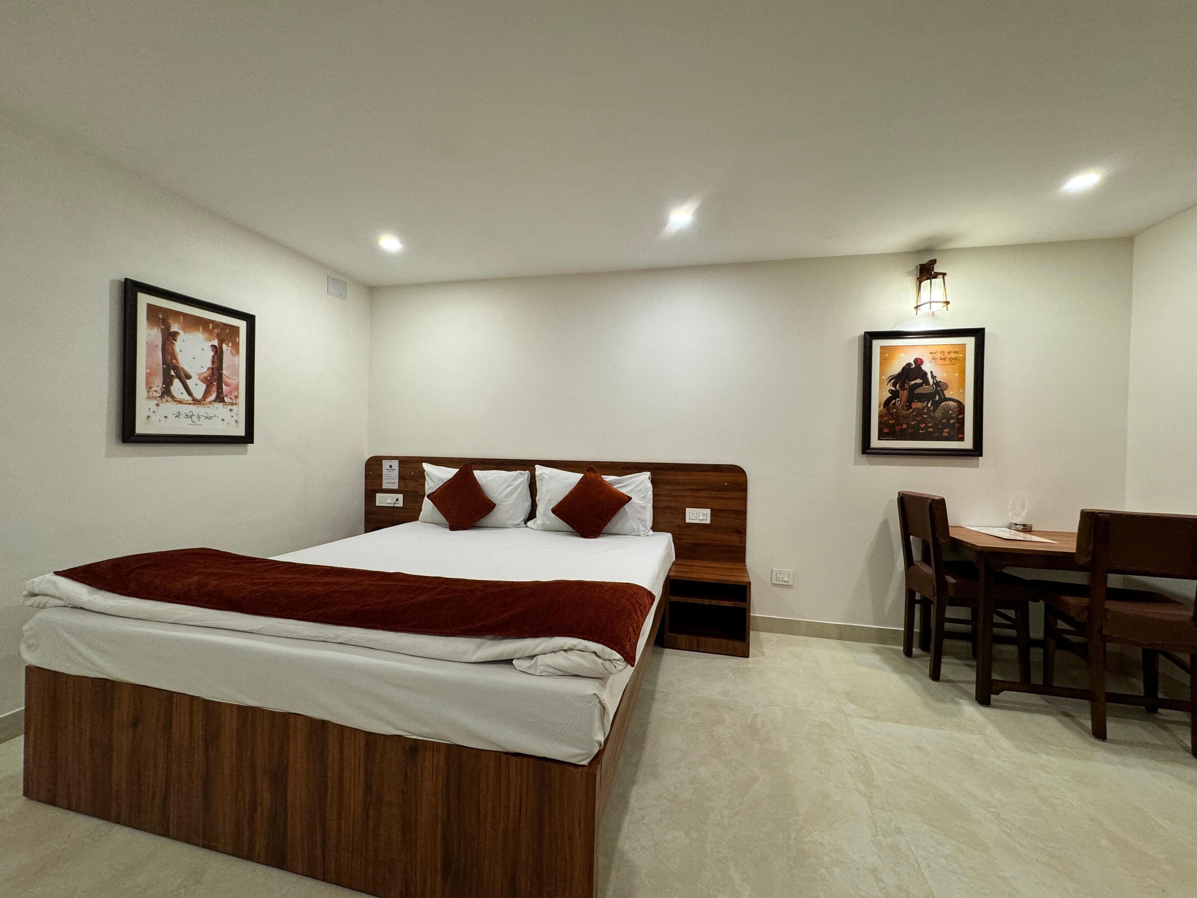 A neatly arranged bedroom with a wooden bed, a desk, and two chairs.