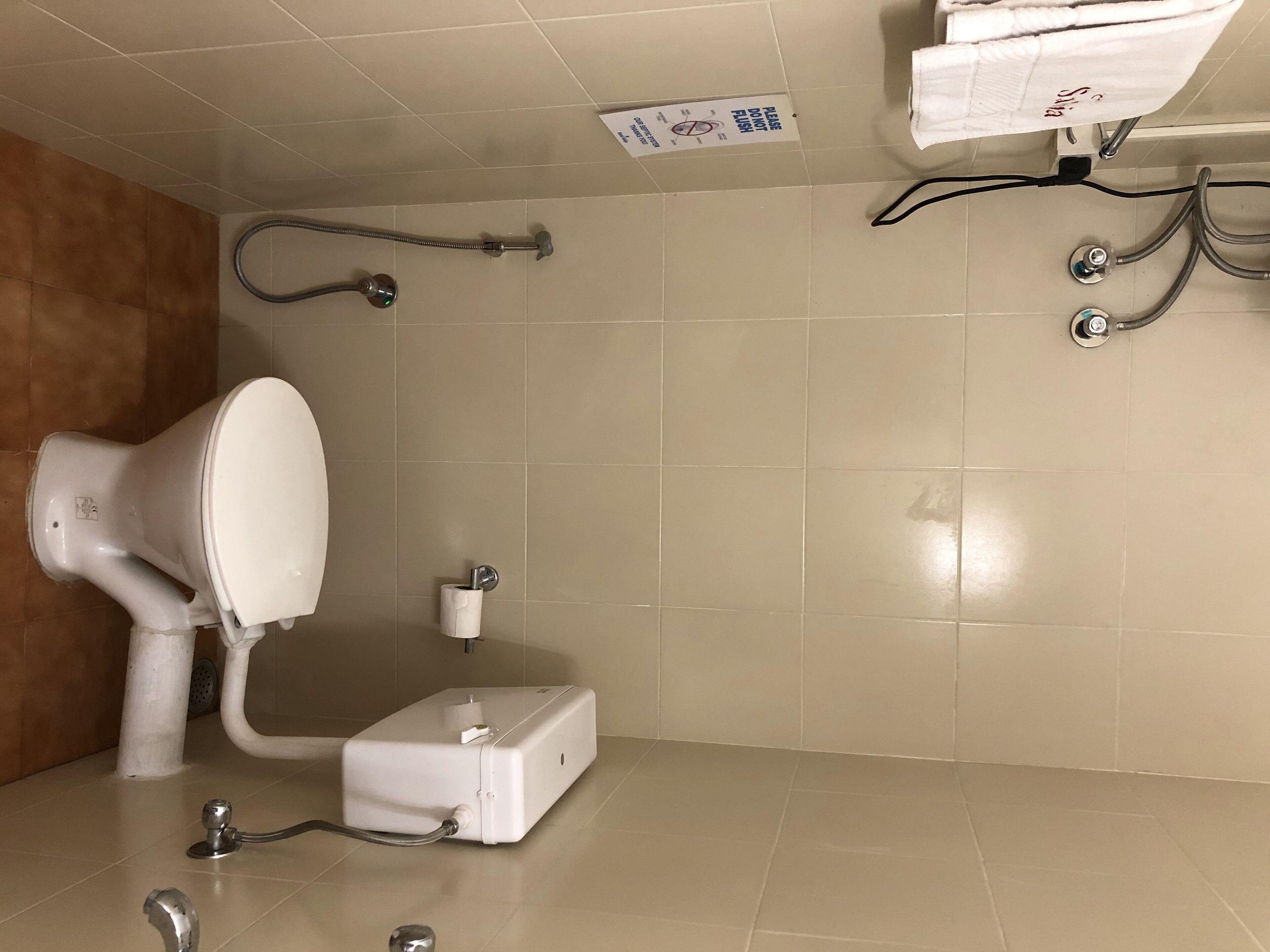 A bathroom with a toilet, bidet, and hand dryer.