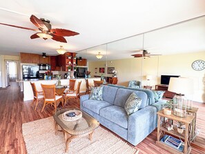 A modern living space with a kitchen, dining area, and a sofa set.