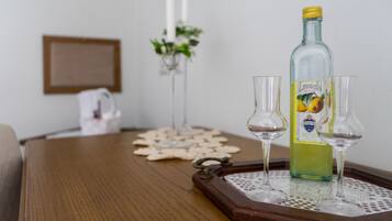 A wooden table with a bottle of Limoncello and two glasses on a tray.