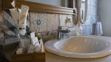 A bathroom with a white sink, a mirror above it, and a towel hanging on the wall.
