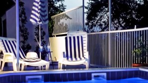 Un área de piscina con sillas de descanso y una valla.