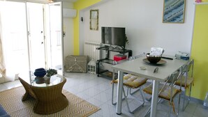 Un comedor con una mesa, sillas, un televisor y un radiador.