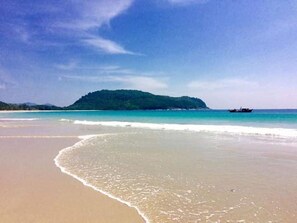 Na praia, areia branca, toalhas de praia 