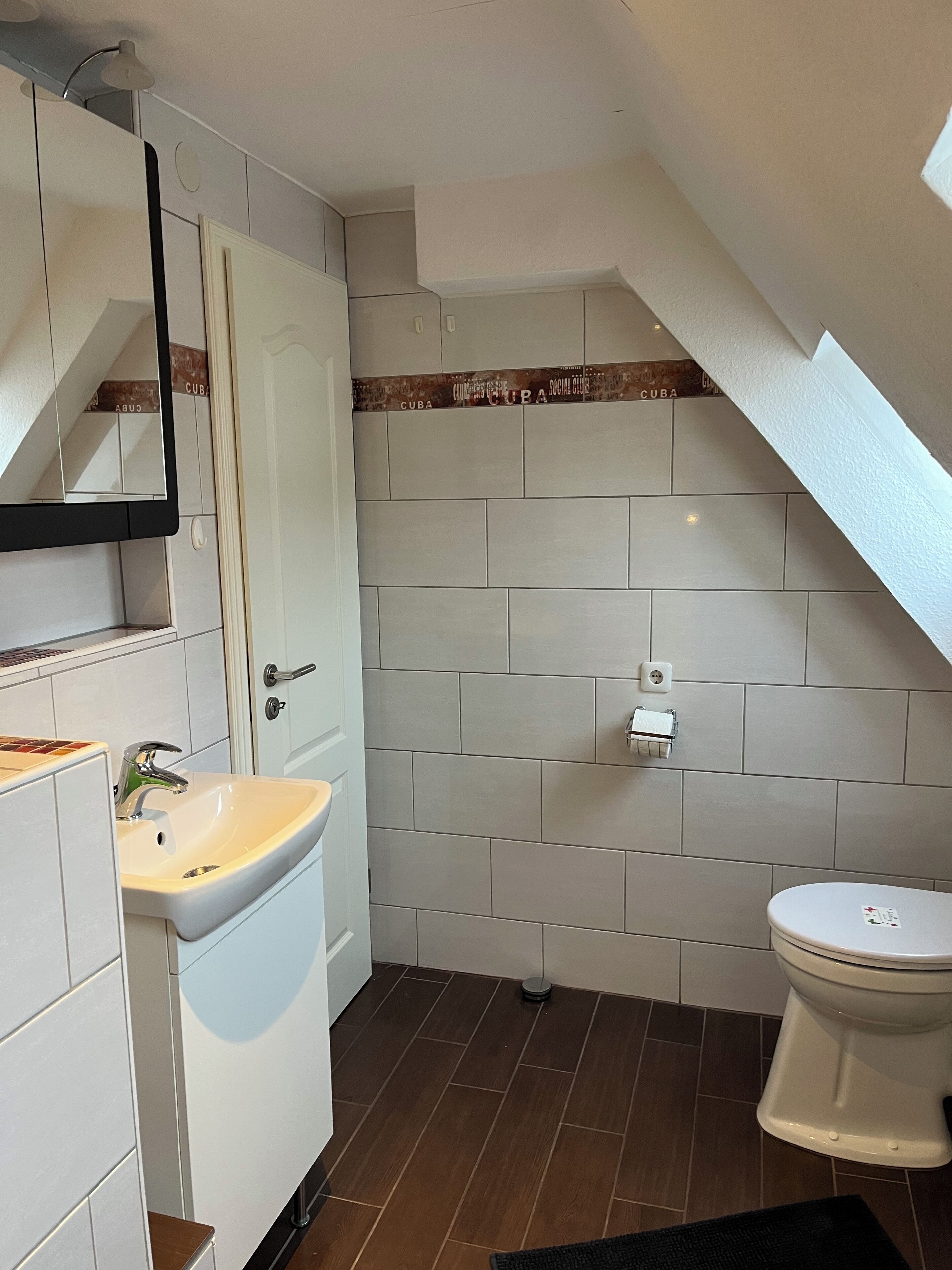 Une petite salle de bain comprenant un lavabo, des toilettes et un miroir.