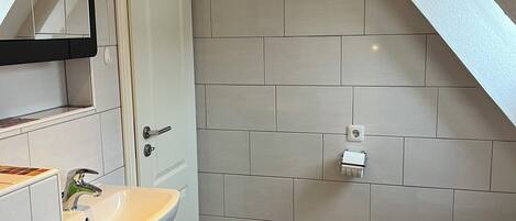 Une petite salle de bain comprenant un lavabo, des toilettes et un miroir.