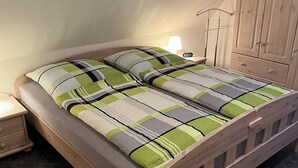 Une chambre à coucher avec un lit en bois, une table de chevet, une lampe et une armoire.