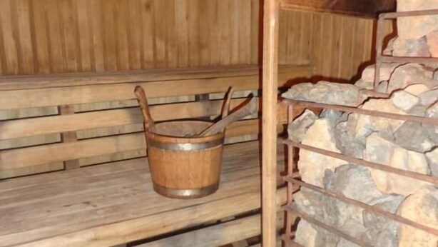 Una sauna con bancos de madera y una pared de piedra.